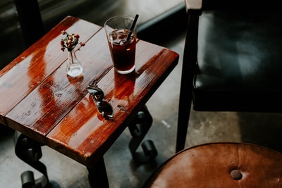 茶杯和太阳镜放在方形的棕色边桌上